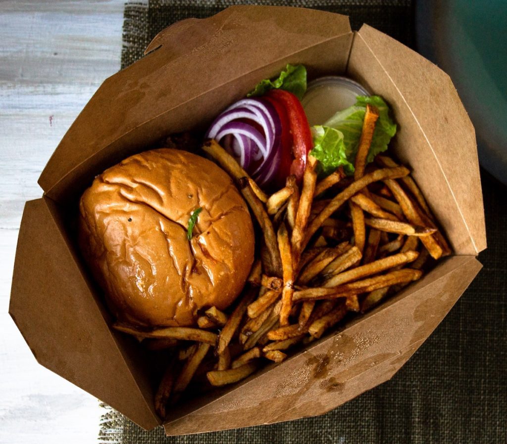 cheeseburger and french fries in a takeout box