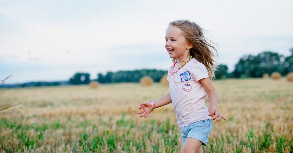 Little girl playing in field