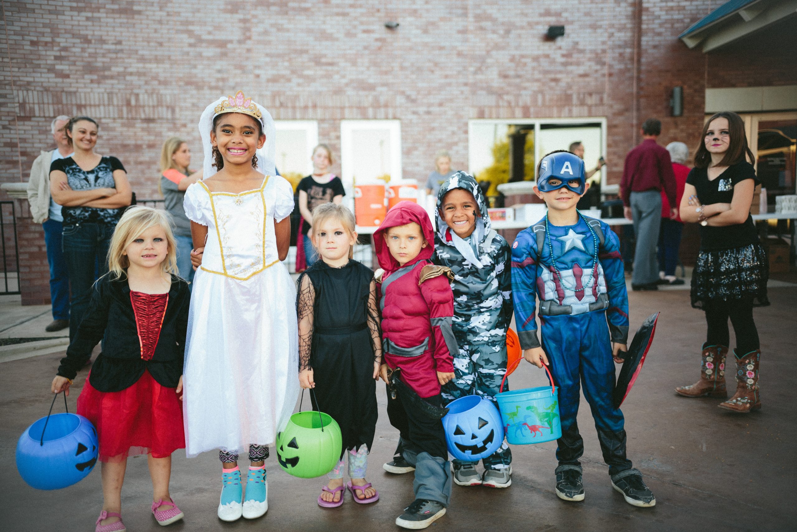 Kids of all ages posing for picture in Halloween costumes