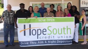 Group of hopesouth employees holding banner